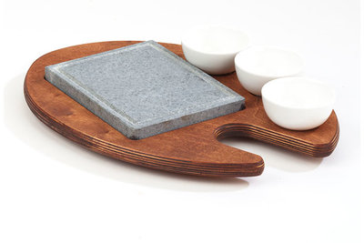 Cooking stone met 3 kommetjes op houten plank 